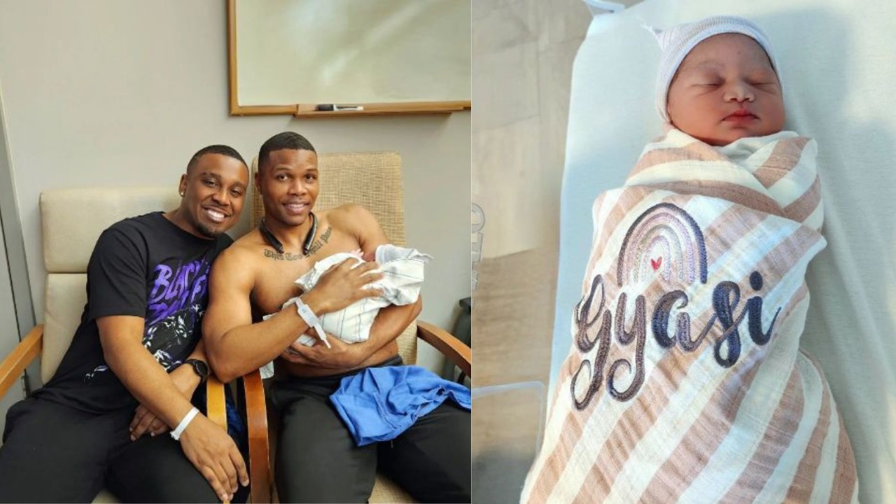 Gay couple holding the baby they had with a surrogate